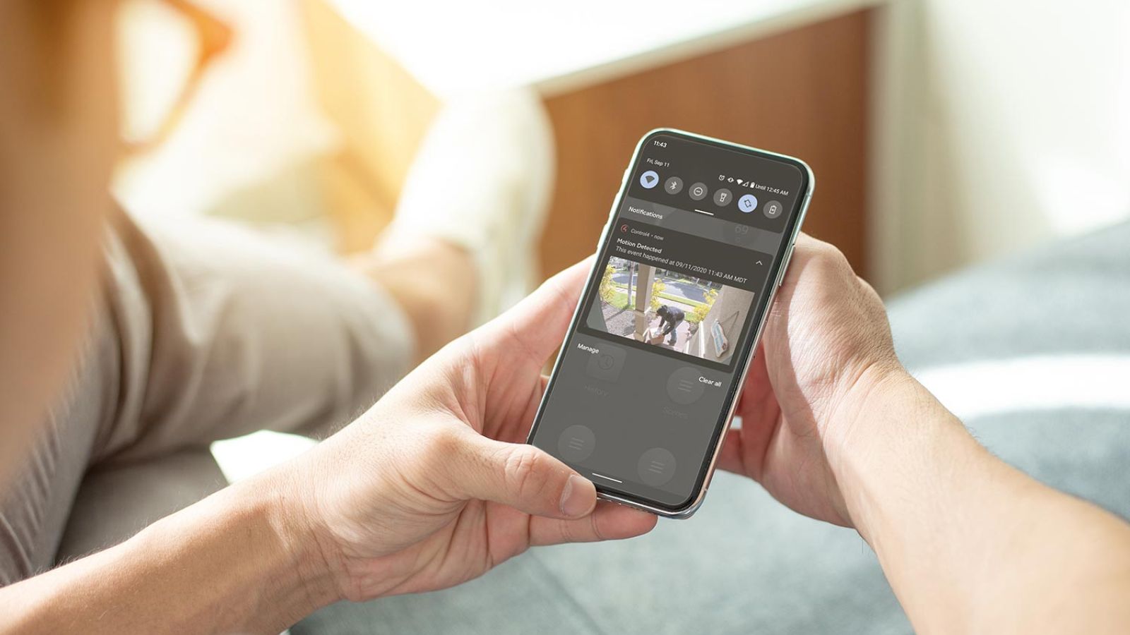Woman with an iPhone Surveillance Control4 screen 